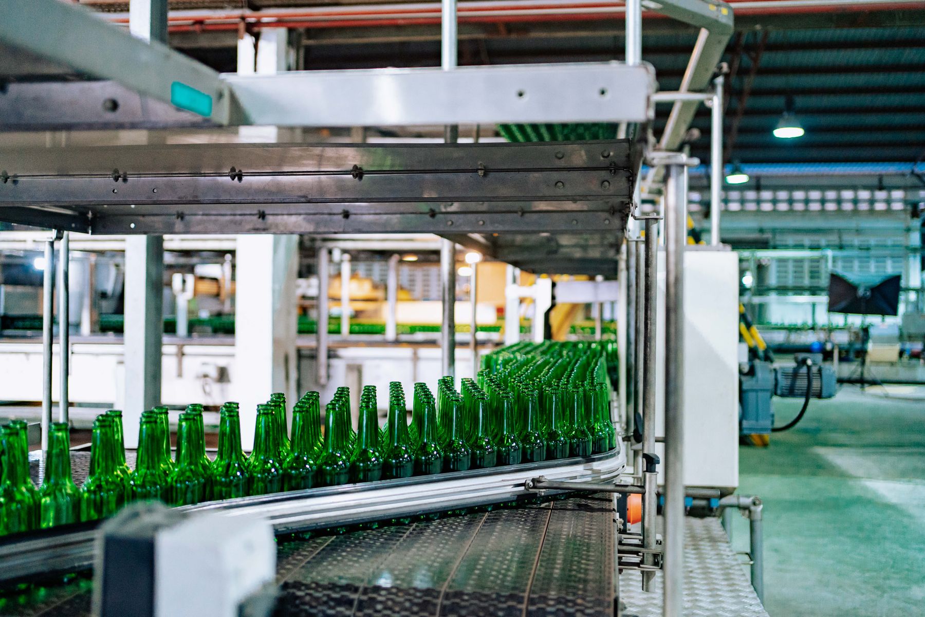 Green glass bottles on an industrial production line