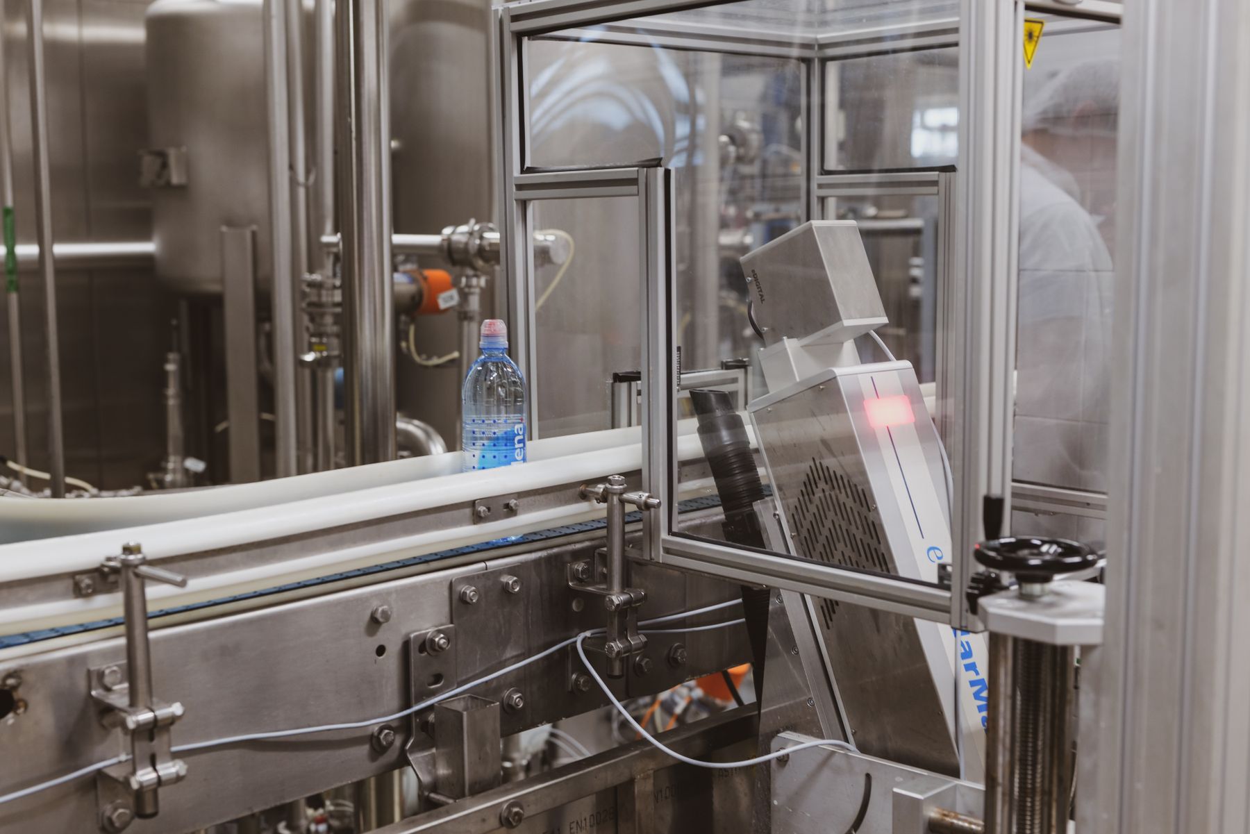 Plastic bottle moving along an automated production conveyor