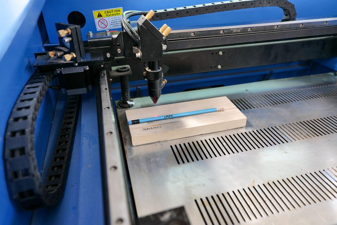 Laser engraving equipment above a wooden workpiece